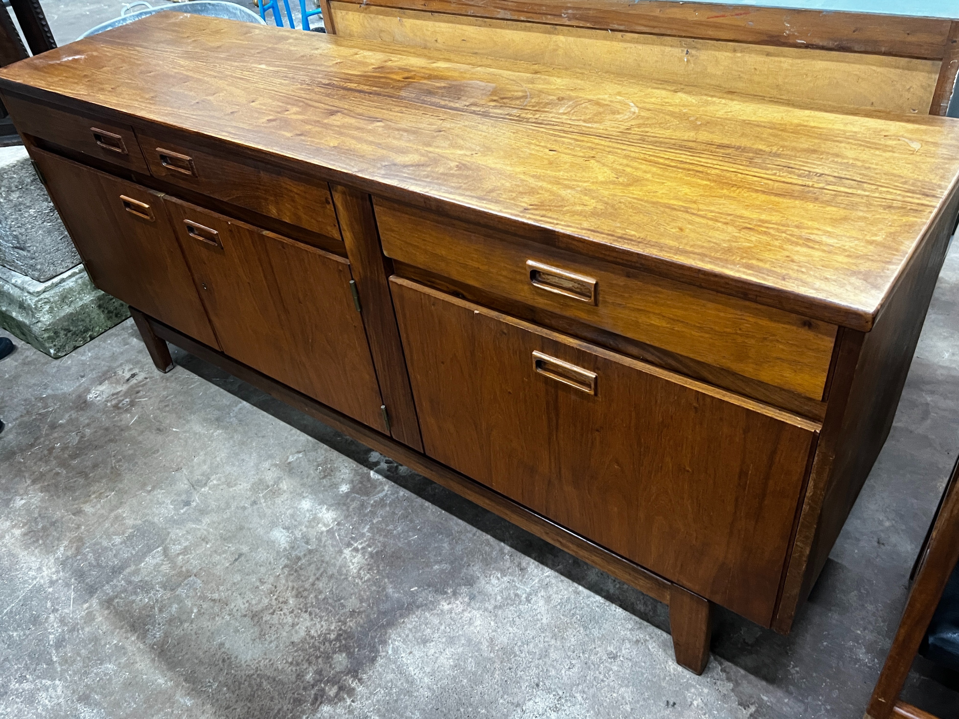 A mid century Novocraft teak dining suite comprising extending dining table 230cm extended, width 97cm, height 74cm, seven black leatherette chairs, one with arms and a sideboard width 178cm.